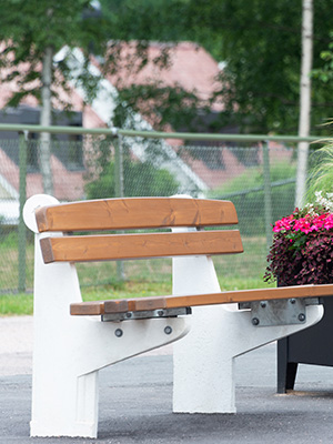 A stylish white cement bench, with soft wood bench and backrest.